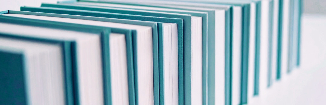 Eine Reihe Bücher mit Buchrücken in Petrol